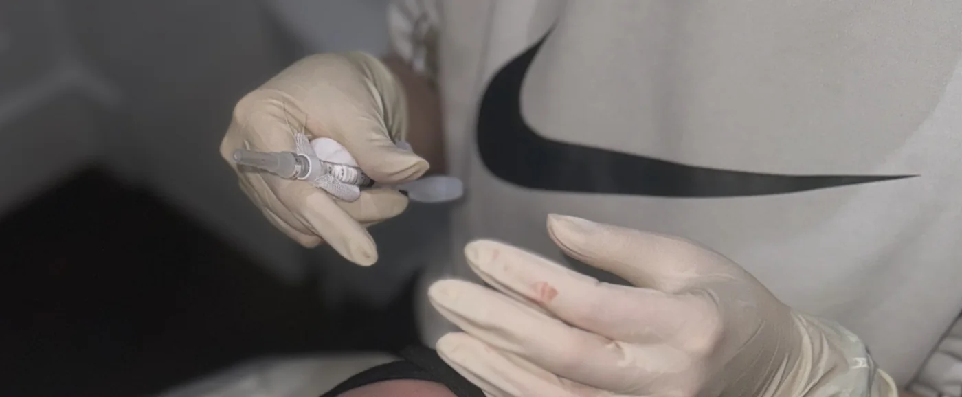A clinician holding a fine dermal filler syringe in gloved hands during a treatment at the Harley Street clinic