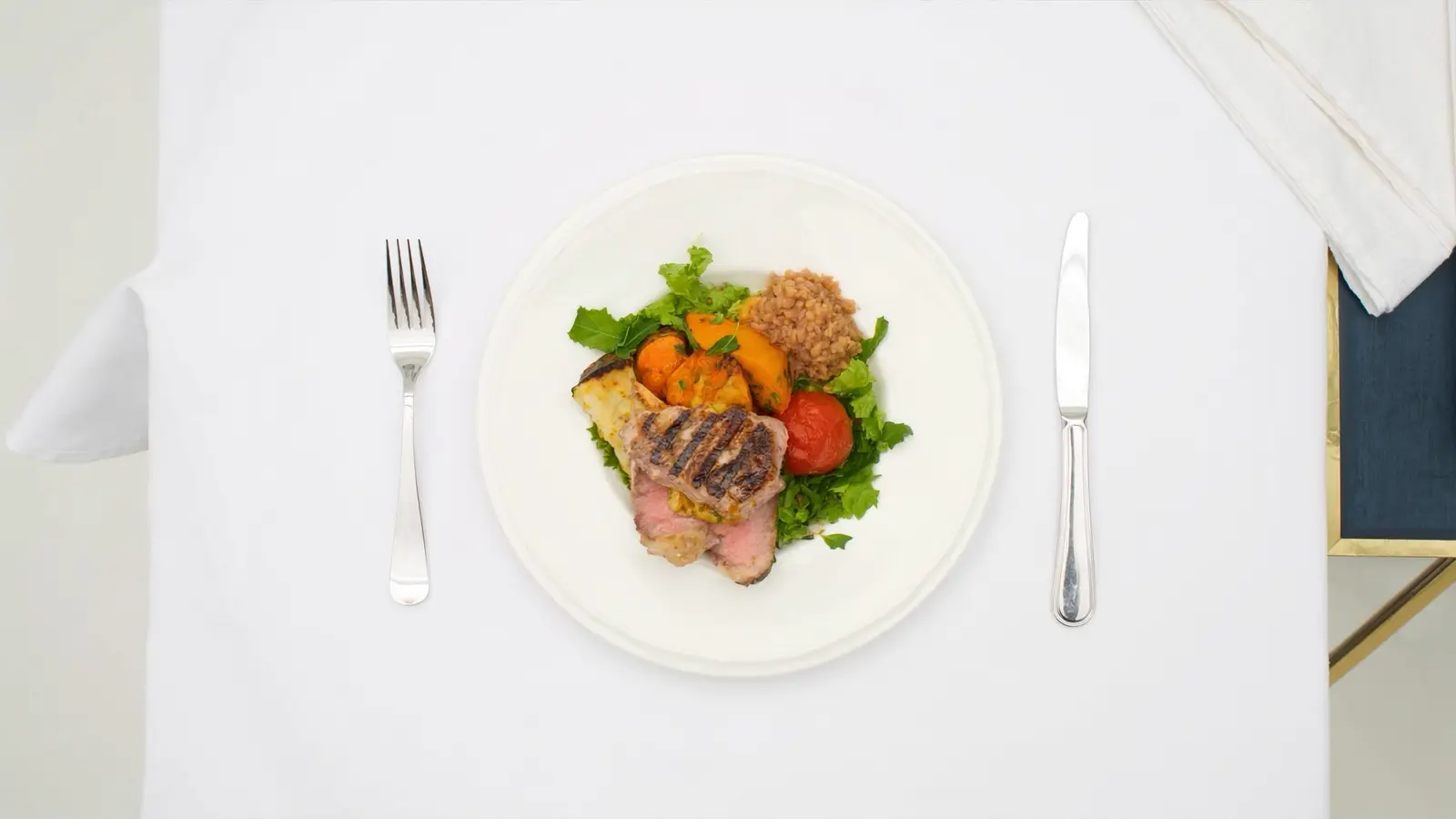 A realistic photographic overhead shot of a balanced high-protein meal (grilled fish, colourful vegetables, lentils) on white
